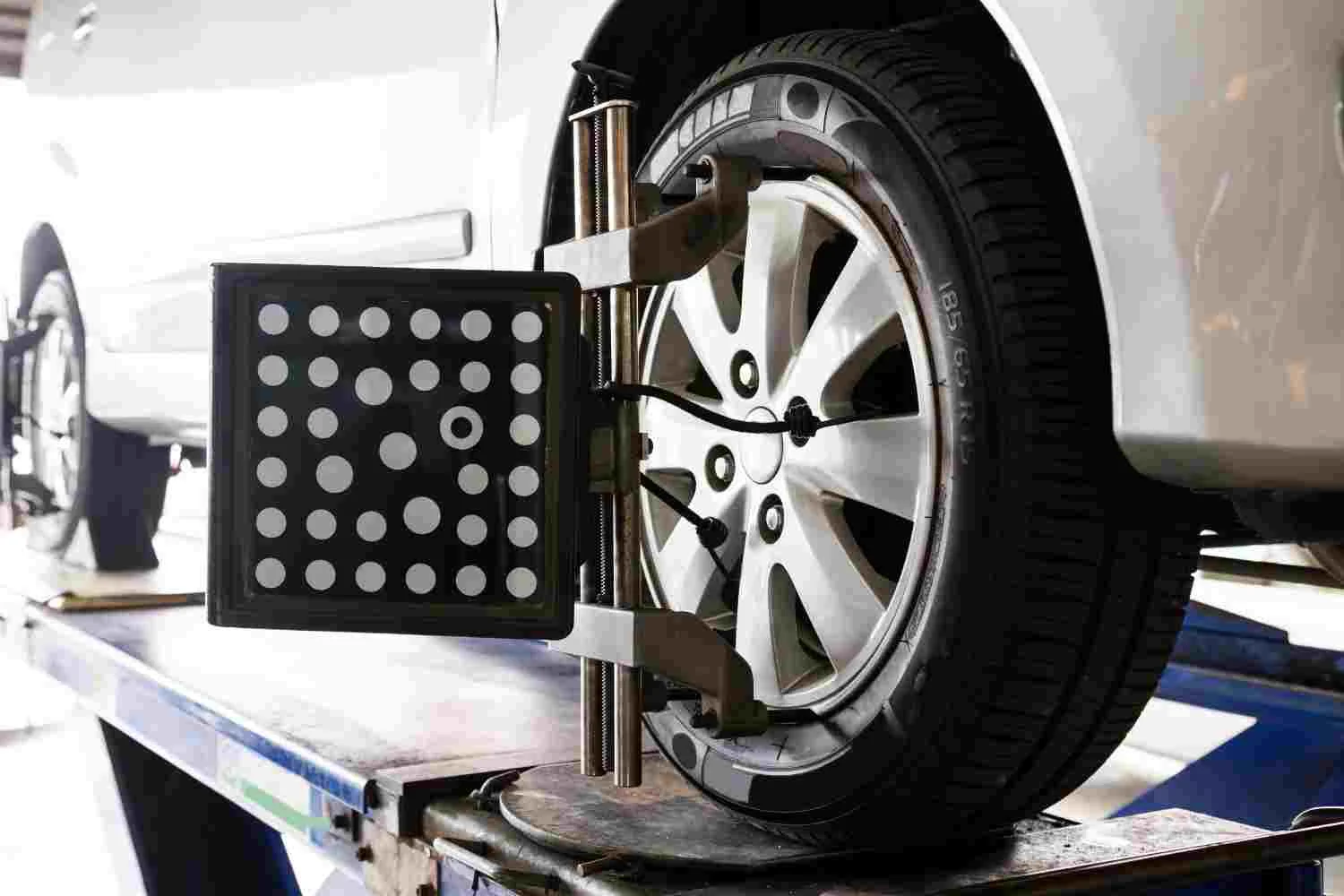 Hunter wheel alignment machine attached to a car wheel during a professional wheel alignment service in an automotive workshop.